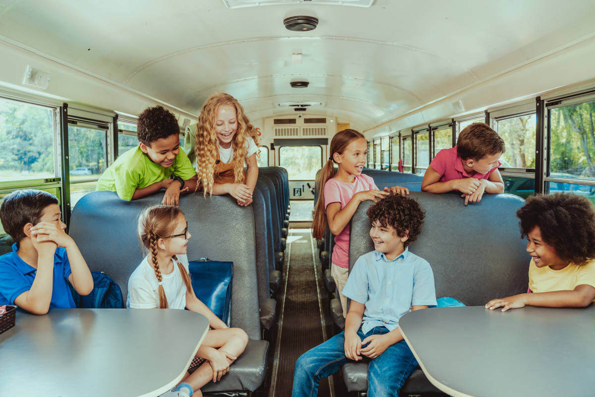 Group of elementary school students sitting inside a yellow school bus